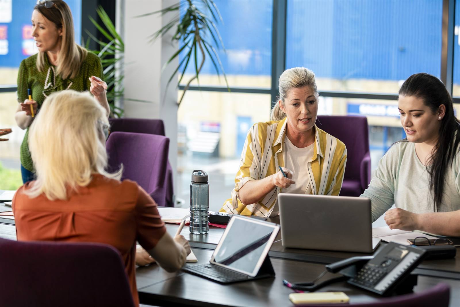Business team in meeting with laptop and notes